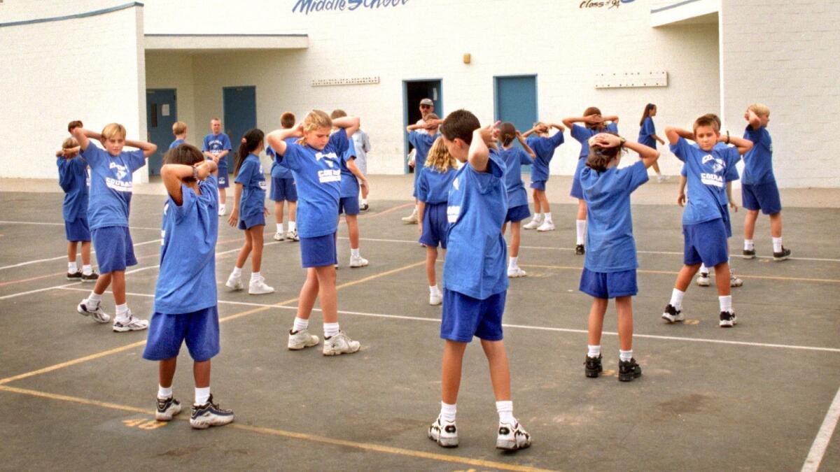 Standardowe spodenki chłopięce wymagane na WF Granatowe spodenki sportowe na chłopcu skaczącego przez skakankę w sali gimnastycznej