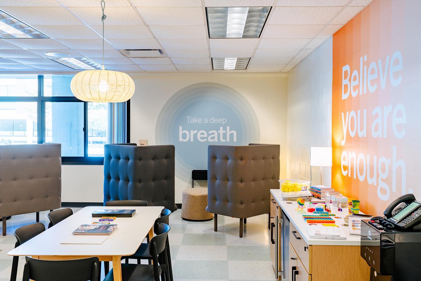 Nastolatek medytuje w pozycji lotosu na macie w cichym pokoju szkolnym