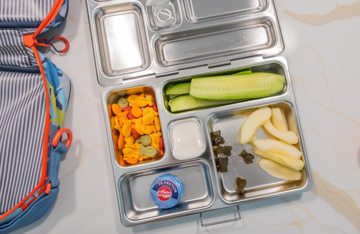 Pełnoziarnista kanapka z serem żółtym wędliną i liśćmi sałaty w pojemniku