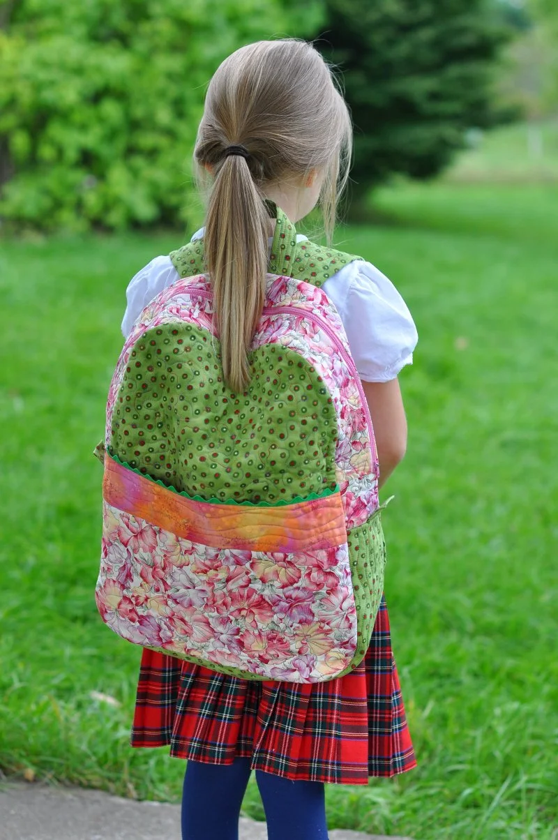 Plecak z ergonomicznymi szelkami dla prawidłowej postawy Dziecko zakłada plecak z szerokimi miękkimi szelkami na ramiona w klasie