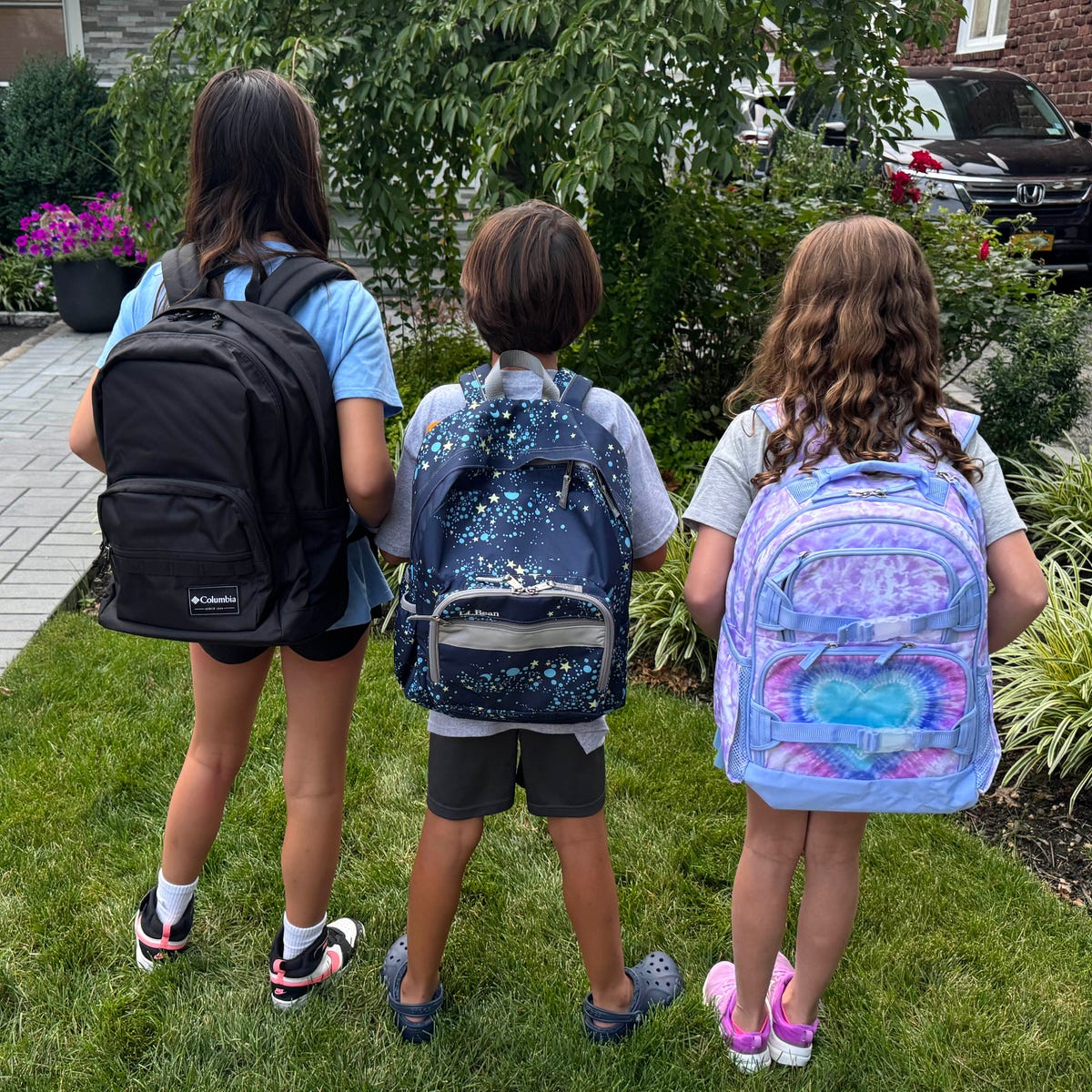 Plecak z zorganizowanymi przegródkami na przybory szkolne Dziecko pakuje książki i zeszyty do głównej komory plecaka z przegrodami